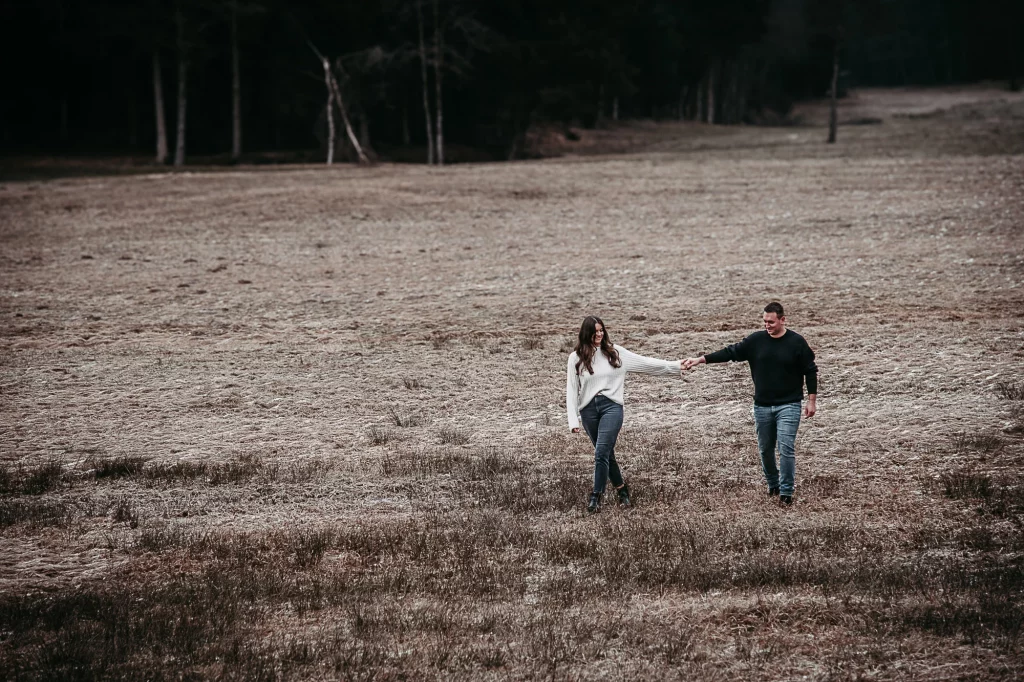 Verlobungsshooting mit einem glücklichen Paar Hand in Hand